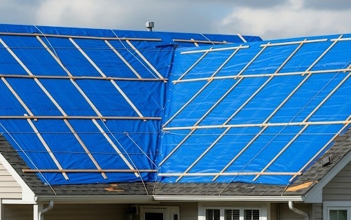 Roof tarping applied to a residential home as a temporary stabilization measure.