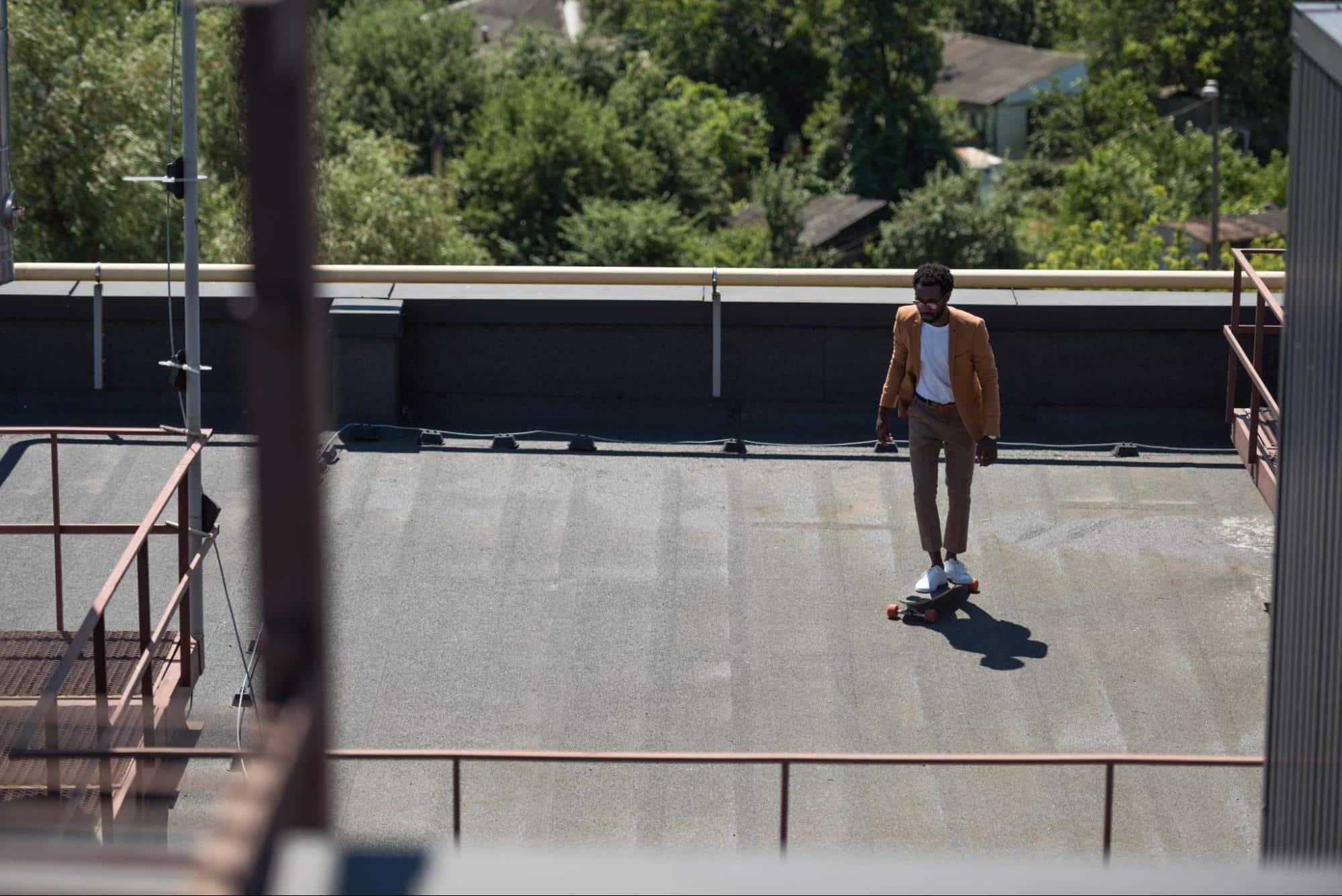 man on longboard in building rooftop