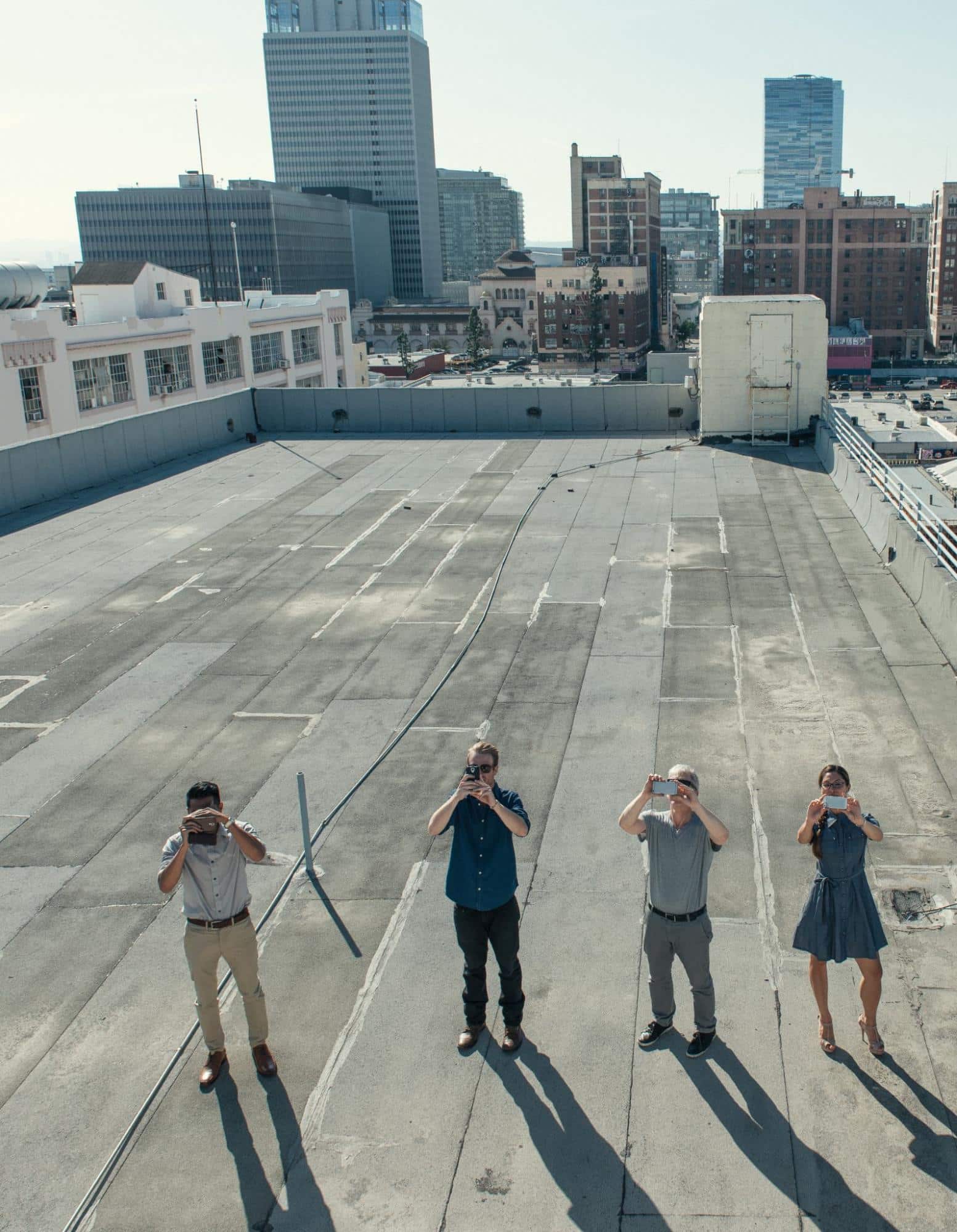 people on a building rooftop taking photos, representing the need for Austin commercial roof inspection
