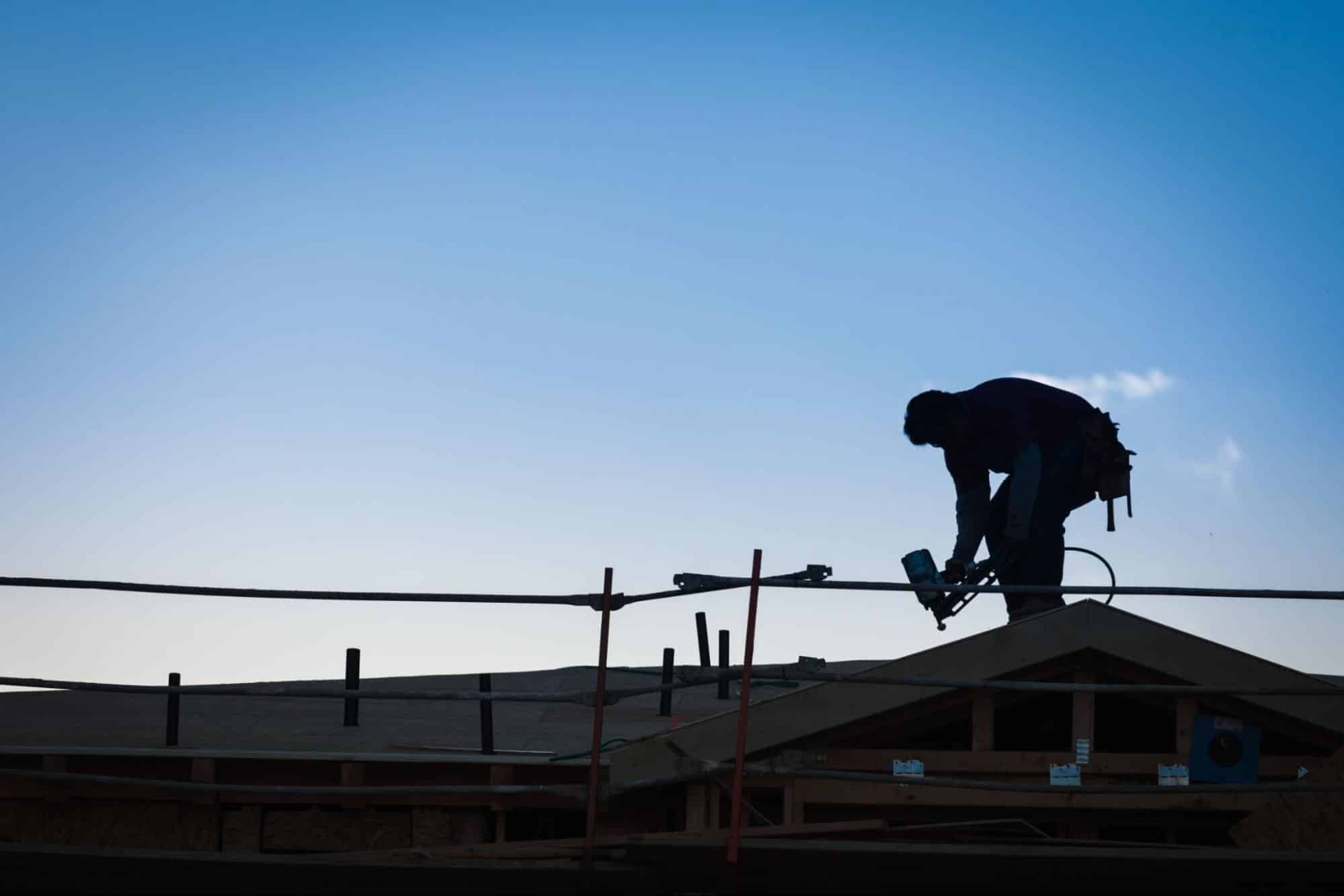 worker on roof of a house